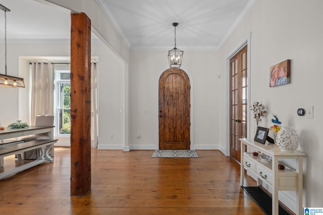 entrance foyer with ornamental molding and hardwood / wood-style floors