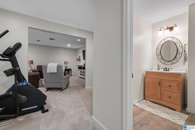 workout room with light colored carpet and sink