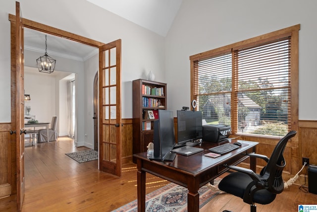 office space with an inviting chandelier, hardwood / wood-style flooring, crown molding, and french doors