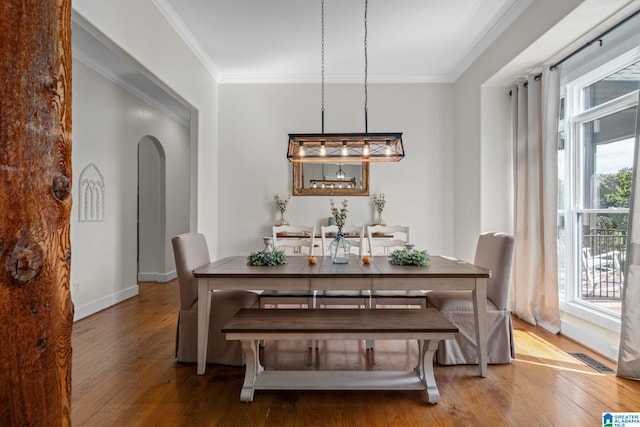 dining area with ornamental molding and hardwood / wood-style floors