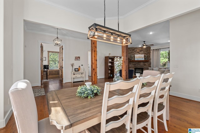 dining room featuring a fireplace, crown molding, dark hardwood / wood-style flooring, and ceiling fan