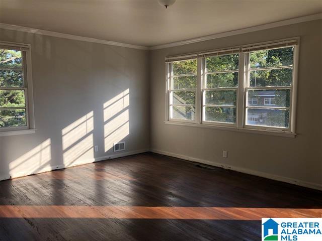 unfurnished room with ornamental molding, dark hardwood / wood-style flooring, and a wealth of natural light