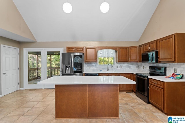 kitchen featuring hanging light fixtures, appliances with stainless steel finishes, a center island, and a healthy amount of sunlight