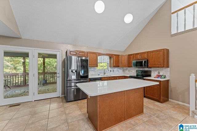 kitchen featuring high vaulted ceiling, appliances with stainless steel finishes, a kitchen island, and a wealth of natural light