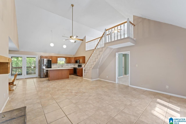 kitchen featuring a kitchen island, high vaulted ceiling, ceiling fan, tasteful backsplash, and appliances with stainless steel finishes