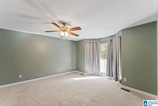 carpeted empty room featuring ceiling fan and a textured ceiling