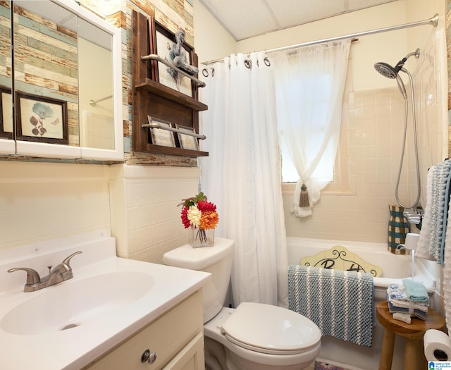 full bathroom featuring shower / tub combo, tile walls, toilet, and vanity