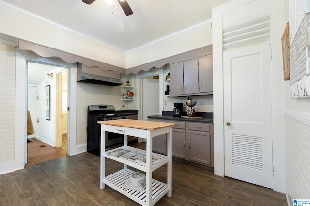 kitchen with ceiling fan, gas range, exhaust hood, gray cabinets, and dark hardwood / wood-style floors