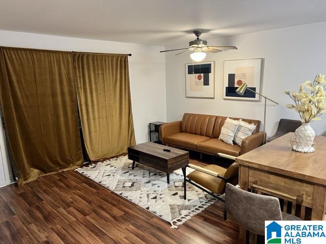 living room with ceiling fan and dark hardwood / wood-style flooring