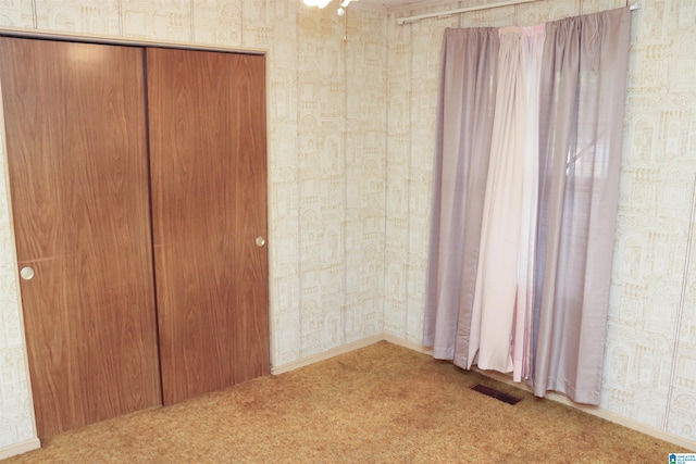 unfurnished bedroom featuring a closet and carpet flooring