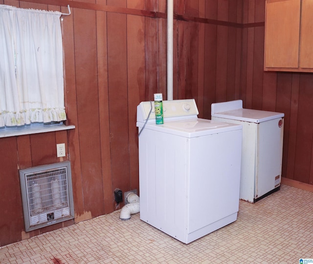 clothes washing area featuring washer / dryer, heating unit, and wooden walls