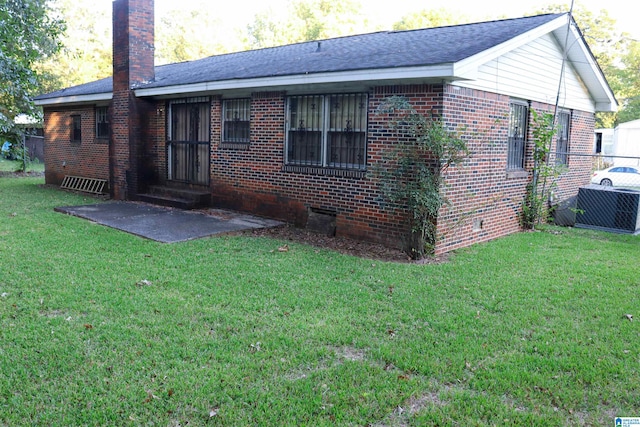 back of house with a lawn and a patio