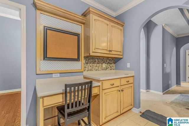 kitchen with ornamental molding, light brown cabinetry, and light carpet