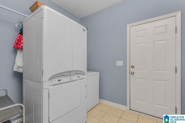 clothes washing area with light tile patterned floors and a textured ceiling