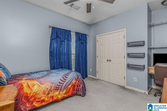 carpeted bedroom with a closet, a textured ceiling, and ceiling fan