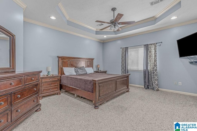 bedroom featuring light carpet, ornamental molding, a tray ceiling, and ceiling fan