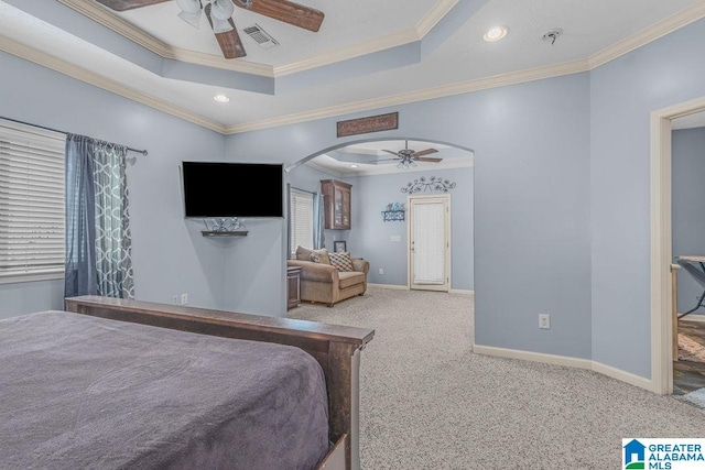 carpeted bedroom with a raised ceiling, ornamental molding, and ceiling fan