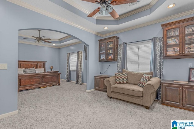 sitting room with a raised ceiling, ornamental molding, and light colored carpet