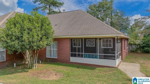 view of front of house with a front yard and a sunroom