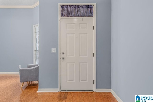 foyer with light hardwood / wood-style flooring and ornamental molding