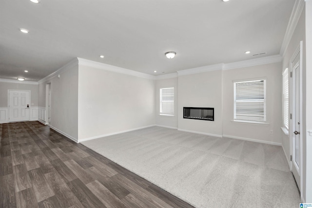 unfurnished living room featuring crown molding and dark colored carpet