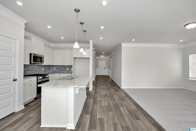 kitchen featuring sink, stainless steel appliances, an island with sink, and white cabinets