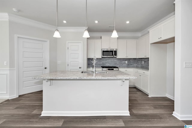 kitchen featuring ornamental molding, sink, a kitchen island with sink, and white cabinets