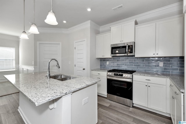 kitchen with appliances with stainless steel finishes, sink, a center island with sink, and white cabinets