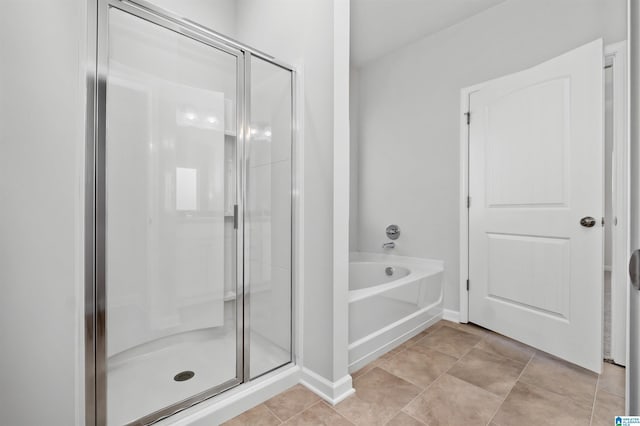 bathroom with tile patterned flooring and separate shower and tub