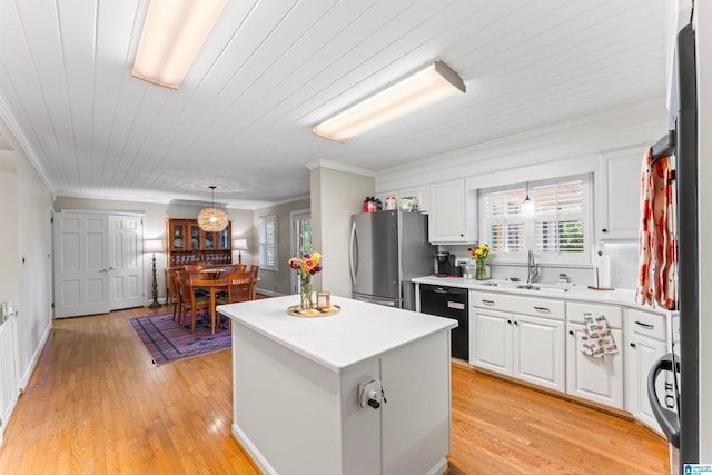 kitchen featuring white cabinets, stainless steel refrigerator, light hardwood / wood-style flooring, and sink