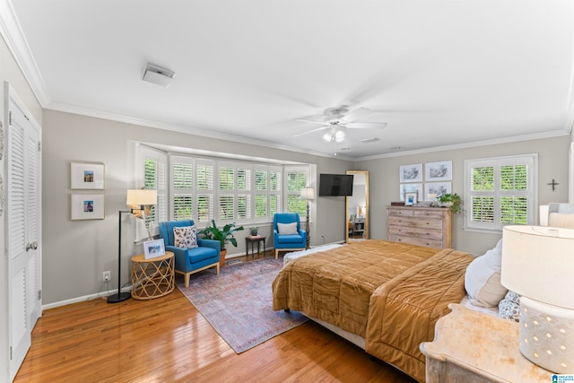 bedroom with ceiling fan, a closet, crown molding, and hardwood / wood-style floors