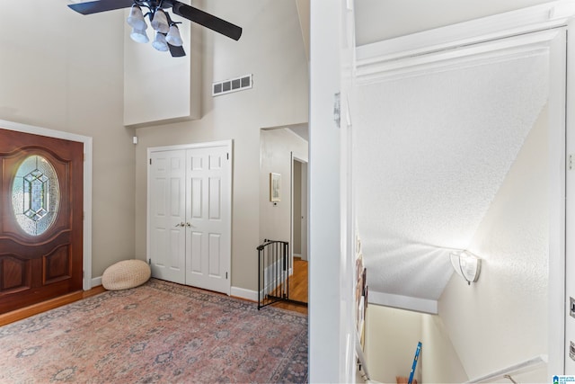 foyer entrance featuring hardwood / wood-style flooring, high vaulted ceiling, and ceiling fan