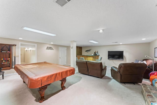 recreation room with light carpet, billiards, and a textured ceiling