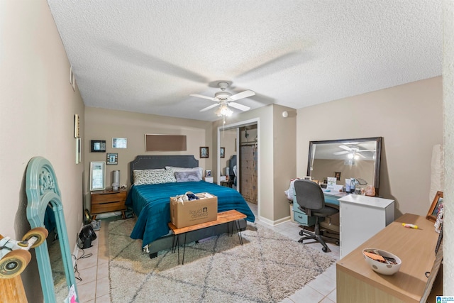 bedroom with ceiling fan, a textured ceiling, a closet, and light tile patterned floors