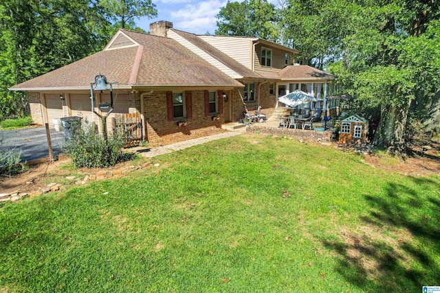 rear view of property with a storage shed and a lawn