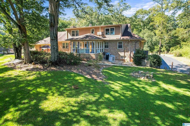 back of property featuring a yard and a sunroom