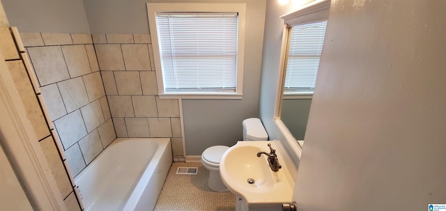 bathroom with tile patterned flooring, sink, a tub, and toilet