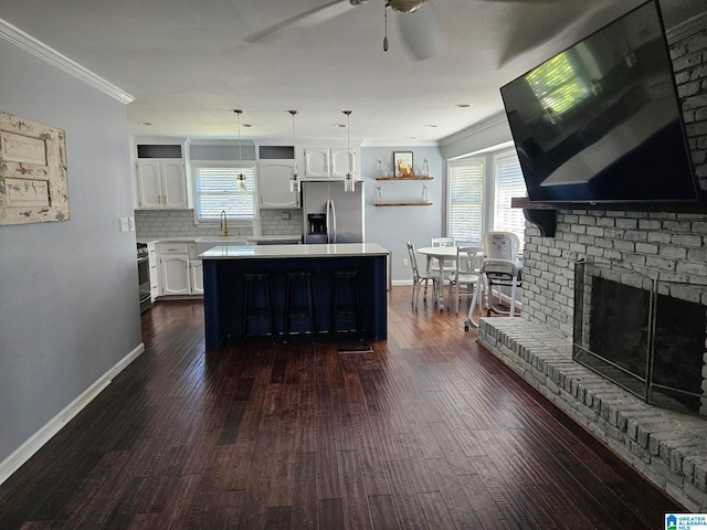 kitchen with appliances with stainless steel finishes, white cabinets, a center island, and plenty of natural light