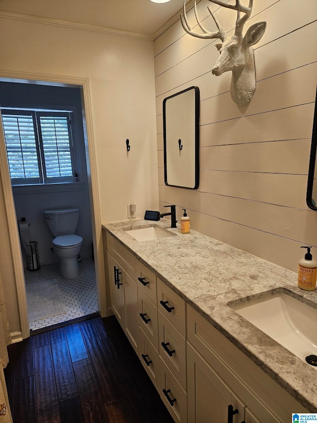 bathroom with vanity, toilet, wood-type flooring, and ornamental molding