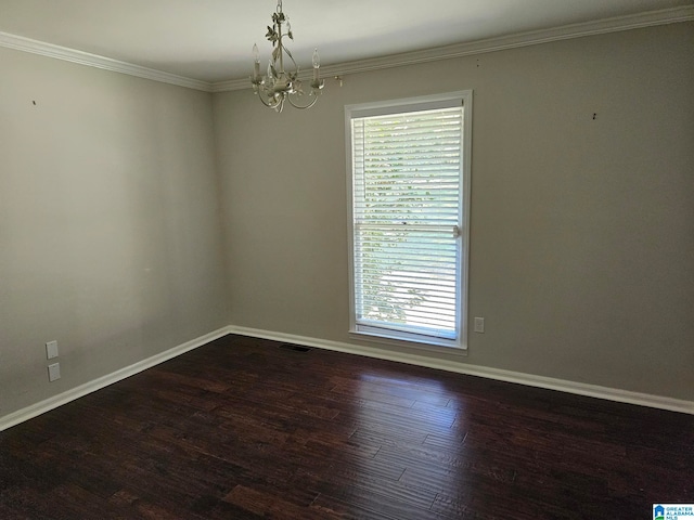 spare room featuring crown molding, dark hardwood / wood-style flooring, and an inviting chandelier