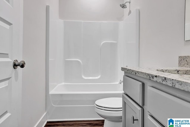 full bathroom featuring vanity, hardwood / wood-style floors, shower / tub combination, and toilet