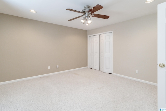 unfurnished bedroom with light carpet, a closet, and ceiling fan