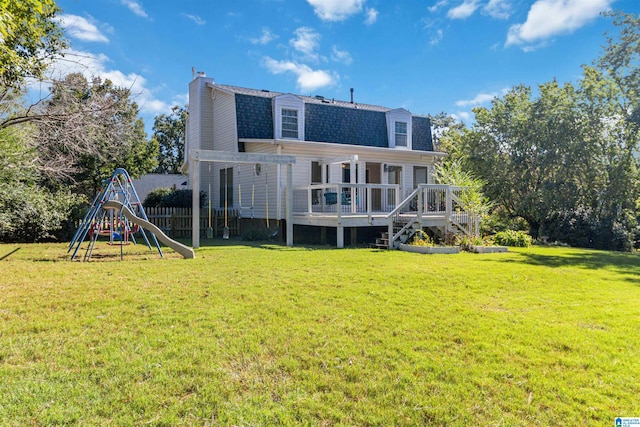 back of house with a playground, a yard, and a deck