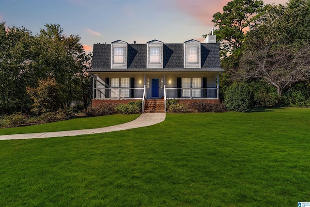 cape cod home with a porch and a lawn