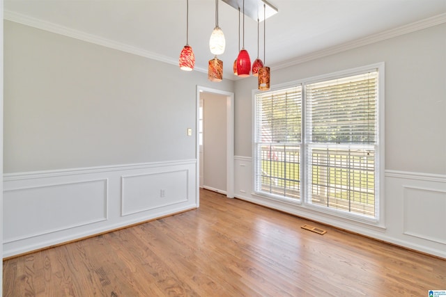 unfurnished room with ornamental molding, plenty of natural light, and hardwood / wood-style floors