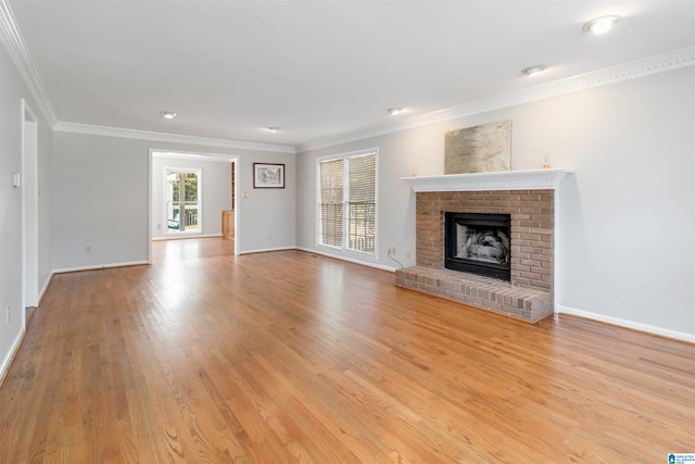 unfurnished living room with a brick fireplace, light wood-type flooring, and crown molding