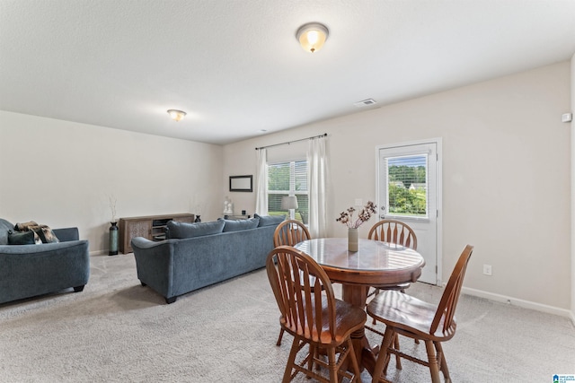 dining area with light carpet and baseboards