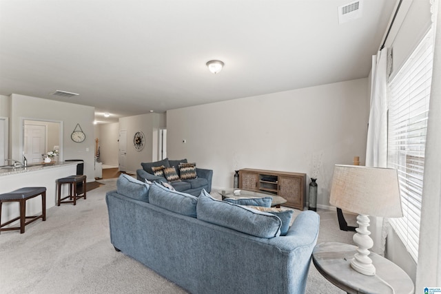 living area with plenty of natural light and light colored carpet