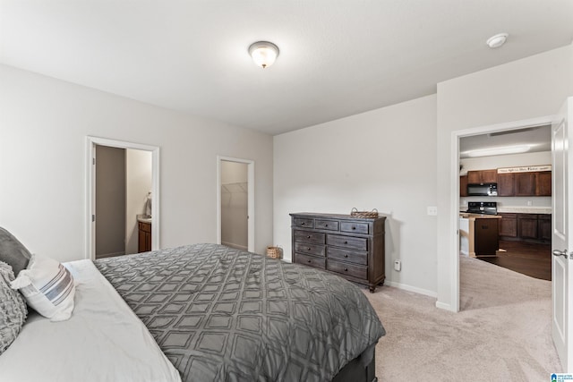 bedroom with light colored carpet, connected bathroom, and baseboards