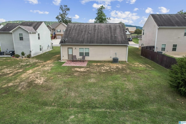 rear view of house featuring a residential view, a patio, central AC unit, and a shingled roof